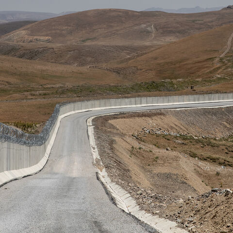 An Iranian border outpost is seen behind a part of Turkey’s newly completed border wall on the Turkey-Iran border, Caldiran, Turkey, July 10, 2021.